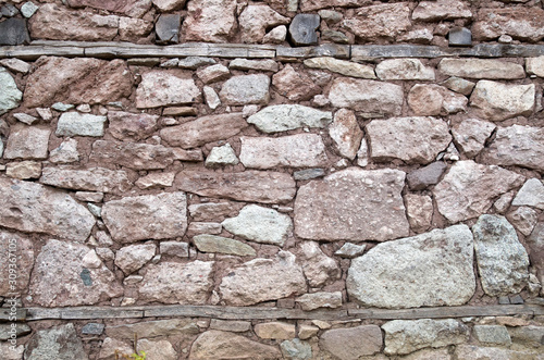 Old stone wall with wooden beams closeup