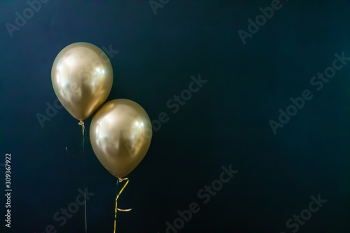 Fotografiet two golden balloons on a dark background