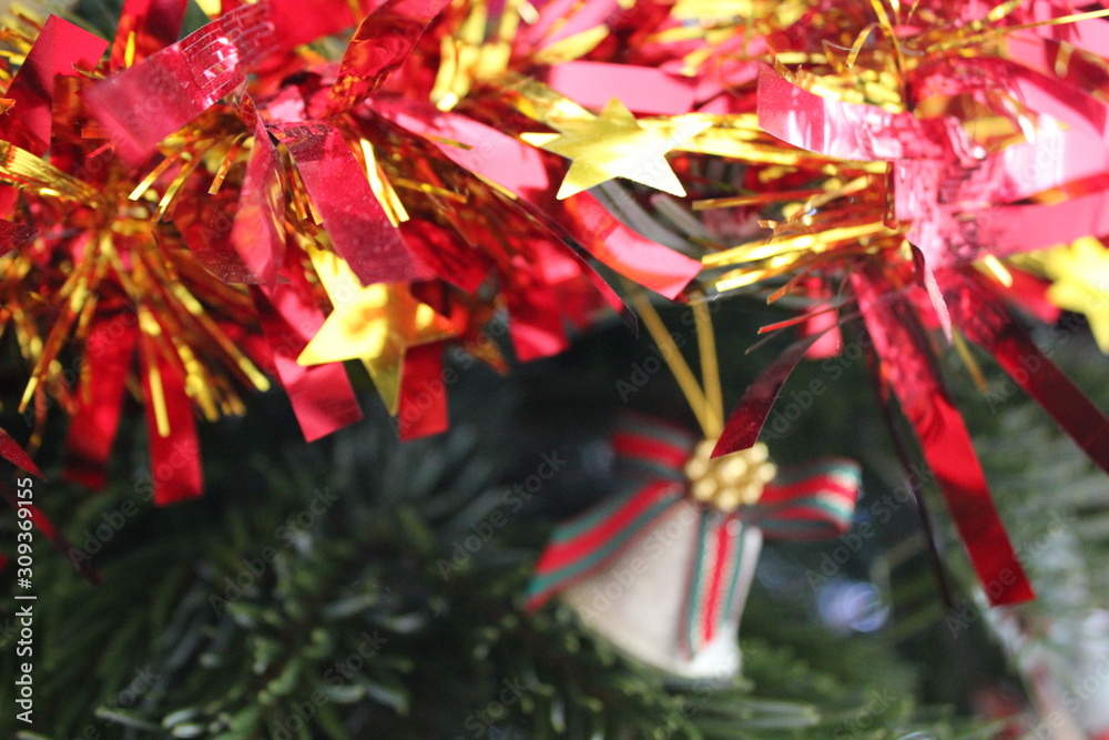 Red and yellow star tinsel on a Christmas tree.
