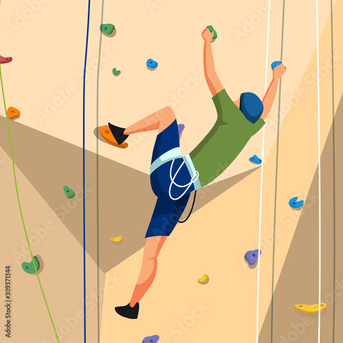 Young man in sportswear training on climbing wall