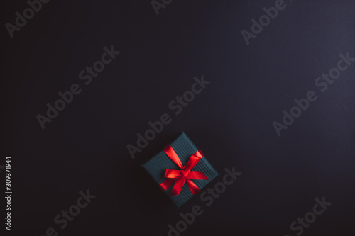 Free Download Gift bandaged with red ribbon on a black background - GFXLoad