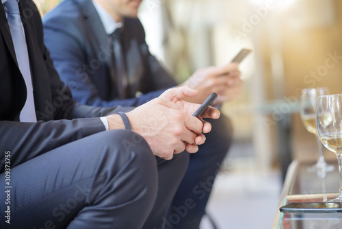 Closeup of businessmen connected with smartphone