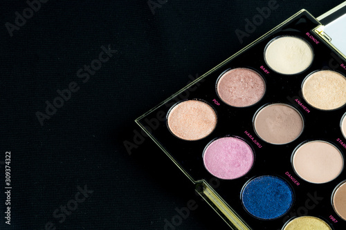Make-up colorful eyeshadow palettes isolated on black background. View from above. 