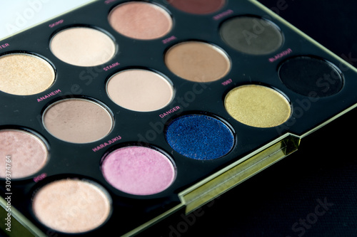 Make-up colorful eyeshadow palettes isolated on black background. View from above. 