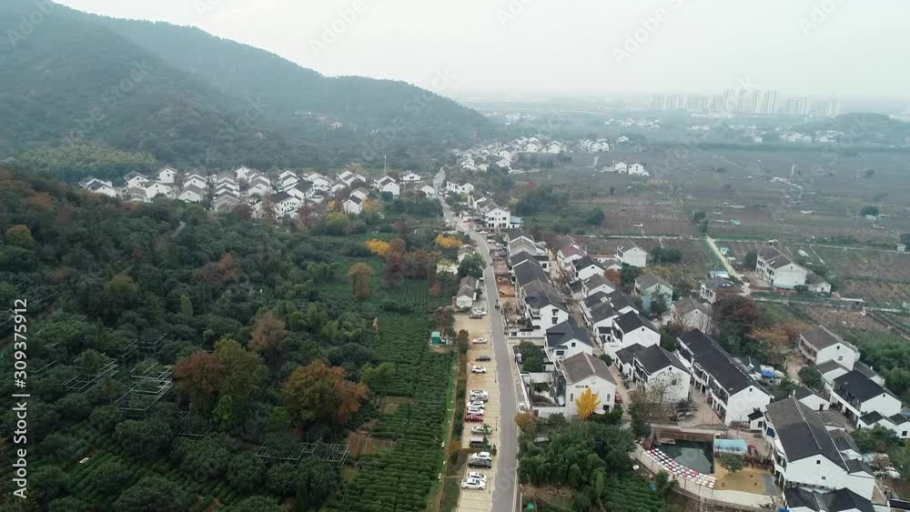 Aerial view of chinese valley and small traditional village surrounded by mountains and hills Aerial view of chinese valley and small traditional village surrounded by mountains and hills