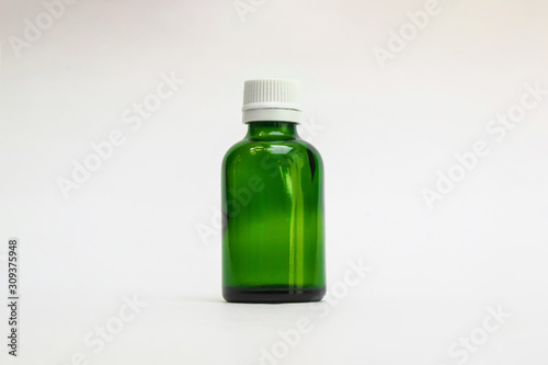 Green color small pharma grade empty glass bottle with white cap. High Resolution. Mock up