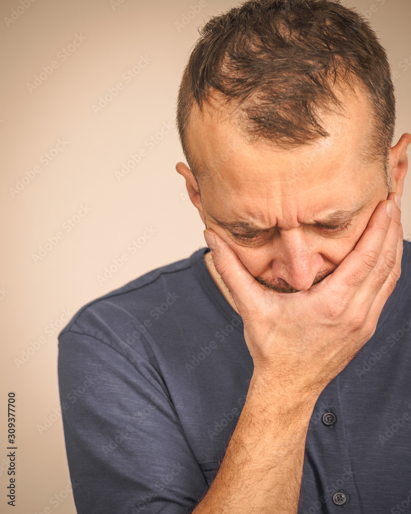 Sad worried man covering his mouth Sad worried man covering his mouth