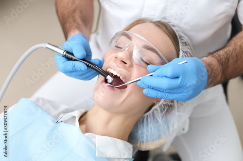 Dentist examines teeth of female patient. Selective focus.