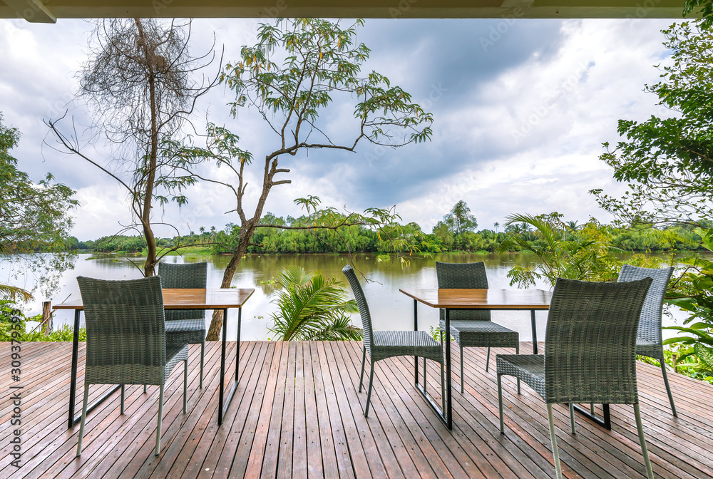 Empty tables and chairs on the riverside with outdoor. - obrazy, fototapety, plakaty 