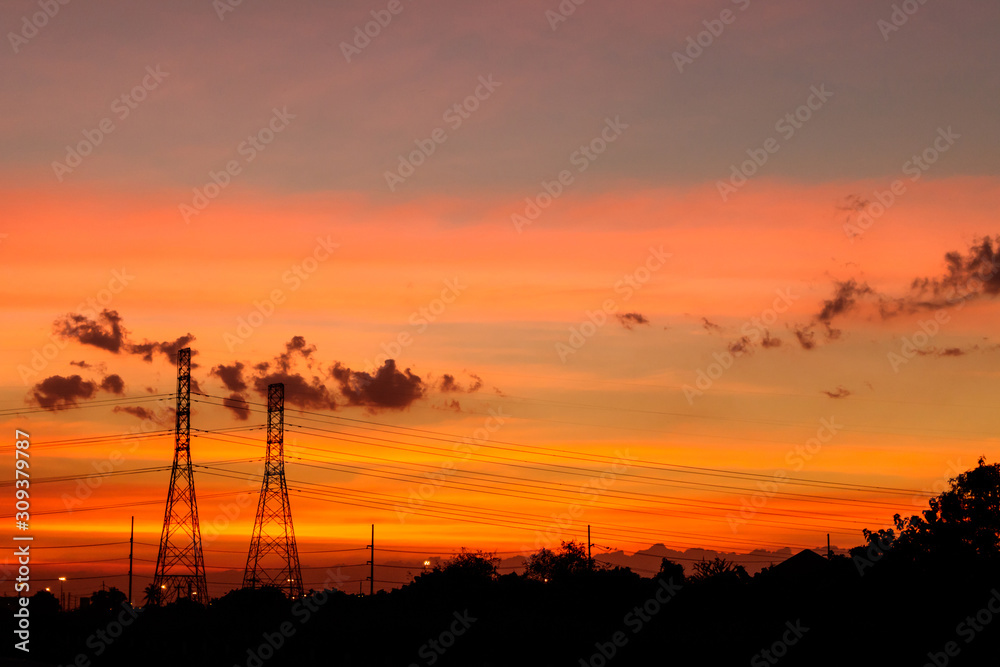 Mobile phone communication antenna tower with silhouette in sunset sky background