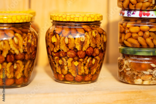 walnuts and peanuts in a jar filled with honey syrup