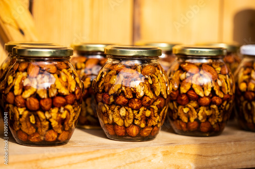 walnuts and peanuts in a jar filled with honey syrup