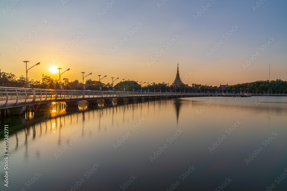 In Khon kaen sunset time at Bueng Kaen nakhon with Wat Phra Mahathat Kaen Nakhon, soft focus, travel concept, lifestyle with copy space.