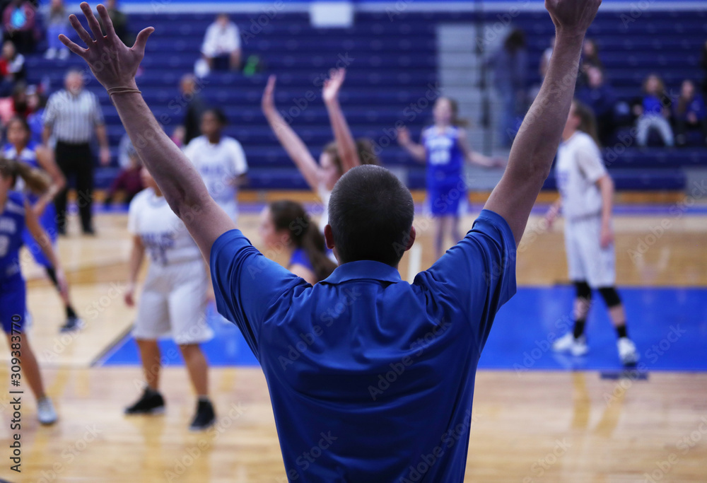 A girls basketball coach calls for defense from his players