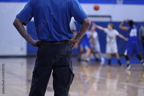 A girls basketball coach watches his defense