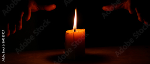 Slika na platnu Candlelight and the magician's hand in the dark, Divine magic & occultism concept
