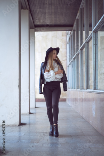 Young Caucasian brunette woman girl in black hat on concrete wall © Сергей Курбатов