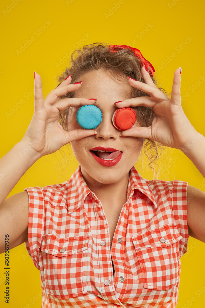 Portrait of nice girl covering her eyes with macaroons Portrait of nice girl covering her eyes with macaroons