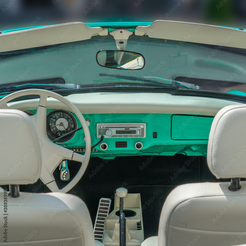 Interior and dash board of a classic car with the steering wheel and the dashboard showing