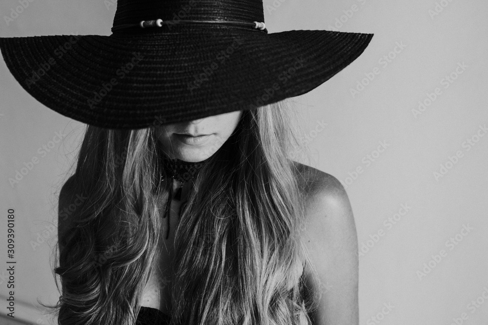 portrait of a beautiful fashionable blonde woman in a black hat with fields portrait of a beautiful fashionable blonde woman in a black hat with fields