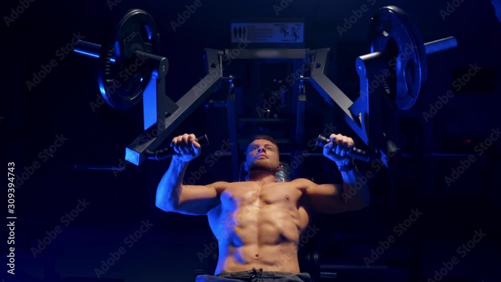 Bodybuilder working out in gym. Strong man during exercise with work ...