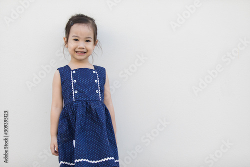 A cute asian girl with a bright blue dress, contrasting with the skin color and white background that everyone will fall in love.