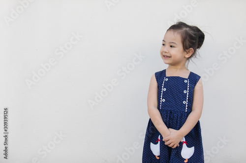 A cute asian girl with a bright blue dress, contrasting with the skin color and white background that everyone will fall in love.