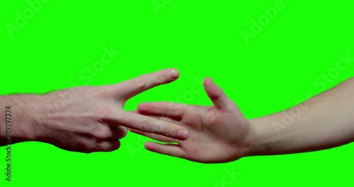 close up of two male hands playing rock paper siccors with greenscreen in background shot in 4k one click keyable photo