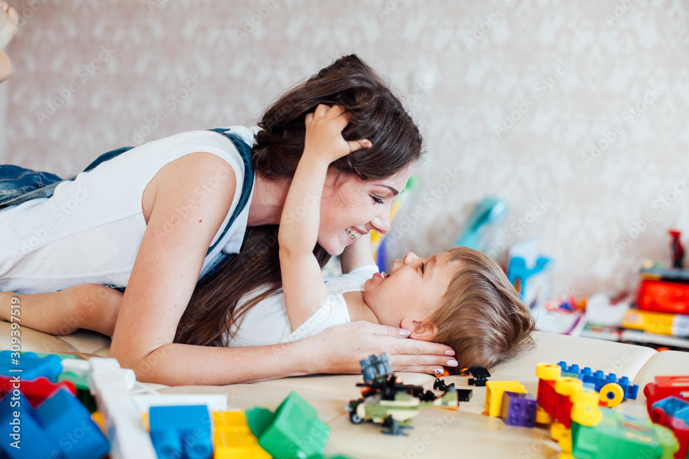 mom plays with a little boy with love kisses laughs mom plays with a little boy with love kisses laughs