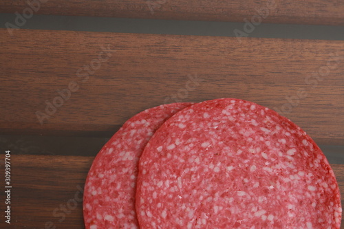 slices of salami on wooden background