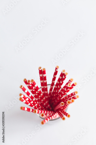 Red tubules for cocktails in a glass on a white background