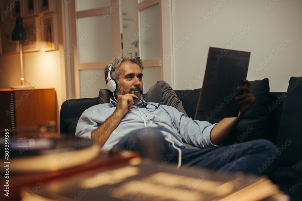 middle aged man listening records at home