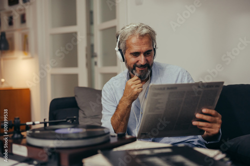 middle aged man listening records at home