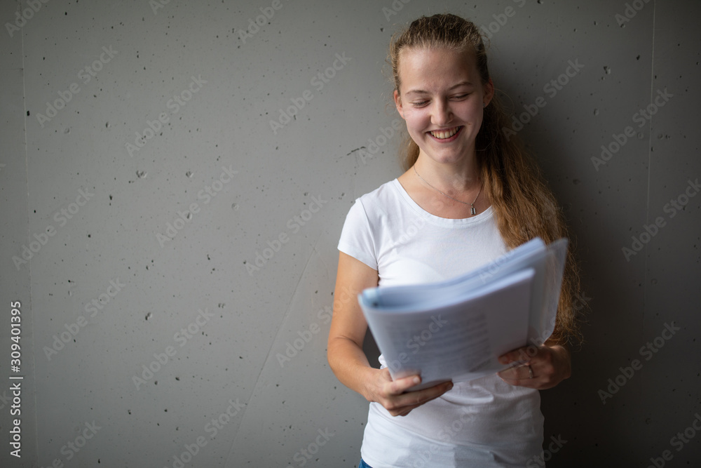 Cute female university/highschool student with books in library - obrazy, fototapety, plakaty 