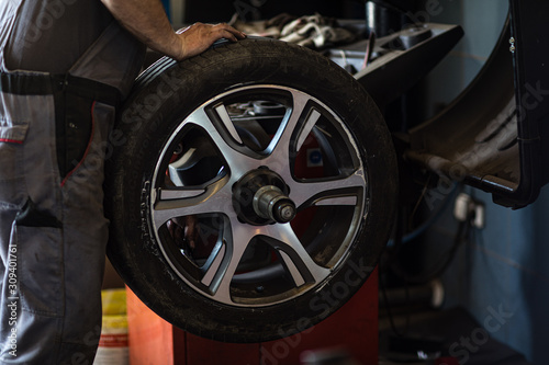 фотографія Wheel balancing or repair and change car tire at auto service garage or workshop