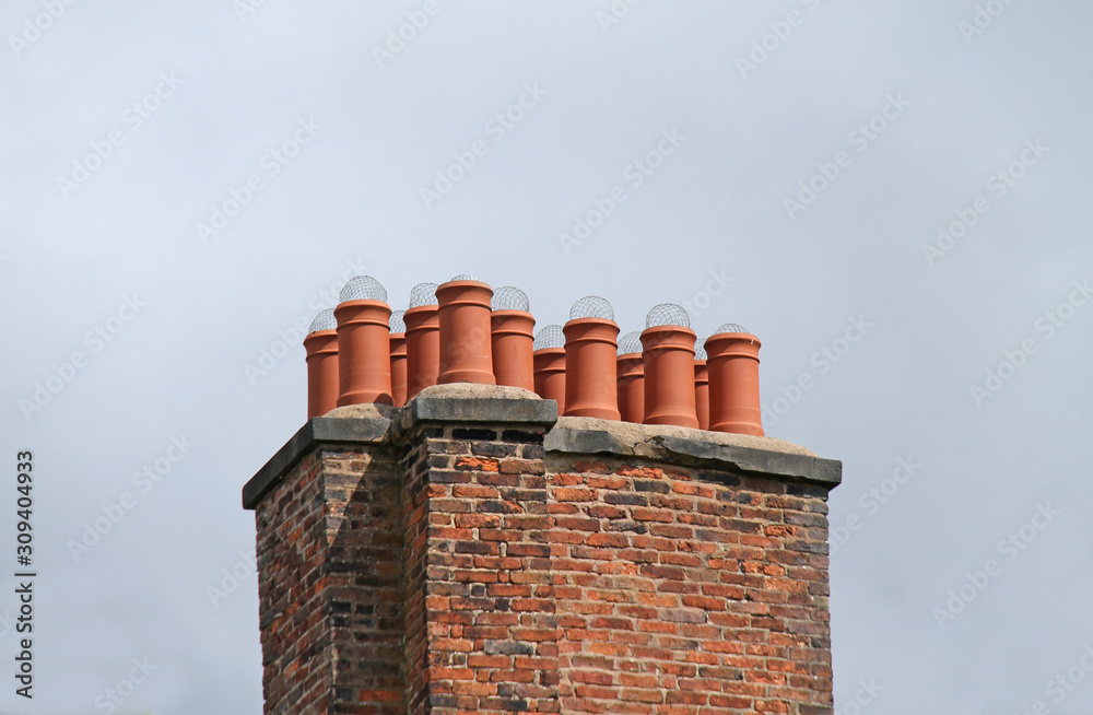 Terracotta Chimney Pots on a Large Brick Chimney. Photos | Adobe Stock