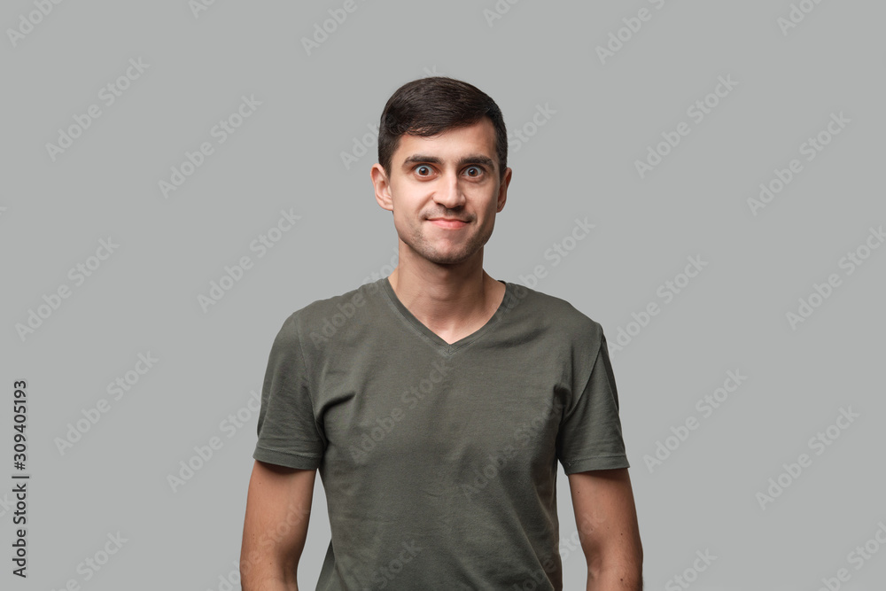 Handsome man in a green tee isolated over grey background Handsome man in a green tee isolated over grey background