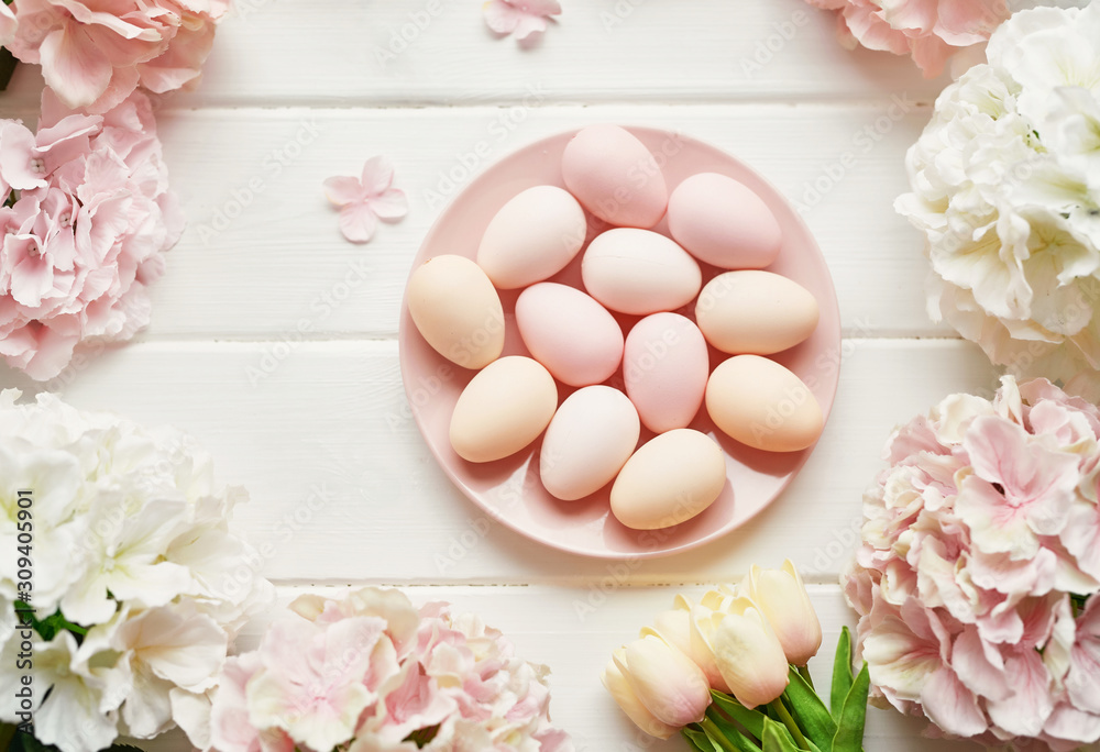 Spring and Easter holiday greeting card concept. Pink and white hydrangeas, yellow tulips with pink eggs. Colorful easter eggs and branch with flowers. Postcard Template. Copy space. Flat lay.