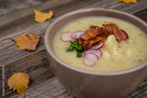 Potato Soup Topped with Bacon, Radish Greens and Radishes photo