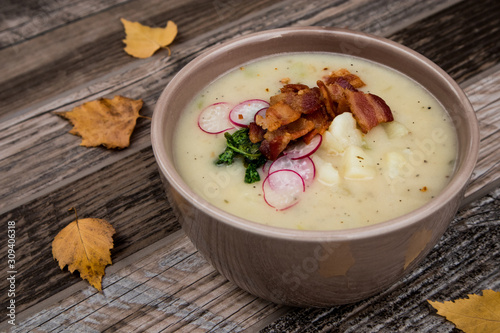 Potato Soup Topped with Bacon, Radish Greens and Radishes photo