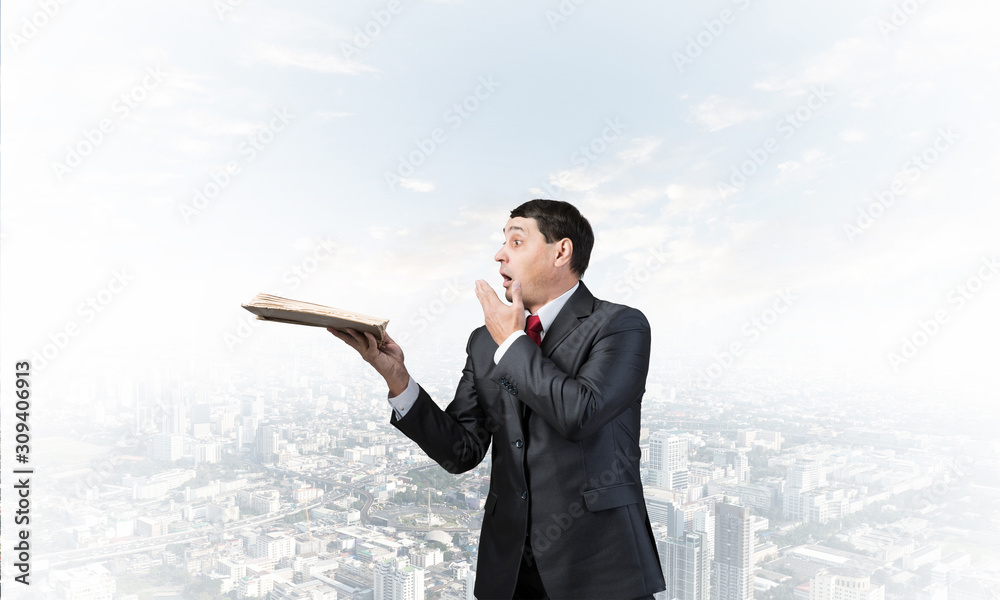 Embarrassed businessman covering mouth with hand