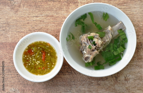 boiled  pork bone in clear soup on bowl dipping with spicy chili sauce