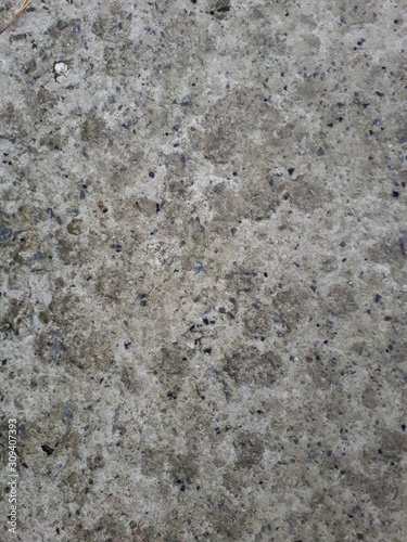  close-up of a decorative wall made of concrete, with a characteristic rough porous texture, abstract dark and light stains