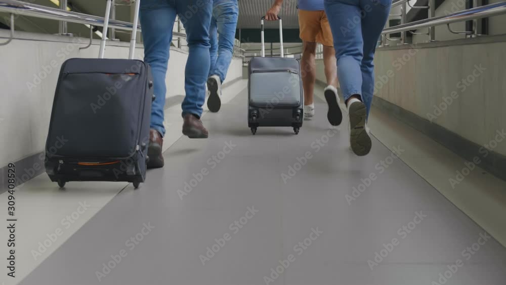 Group of tourists running in airport being late for plane.