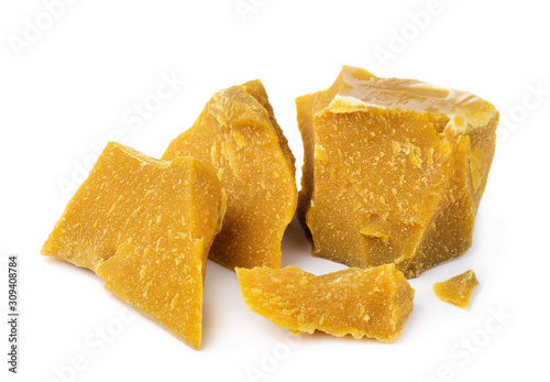 Pieces of organic beeswax on a white background. The use of beeswax in apitherapy. Production Ingredient for Medical and Cosmetics