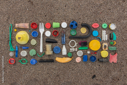 spilled plastic garbage on the beach, dirty sea sandy shore