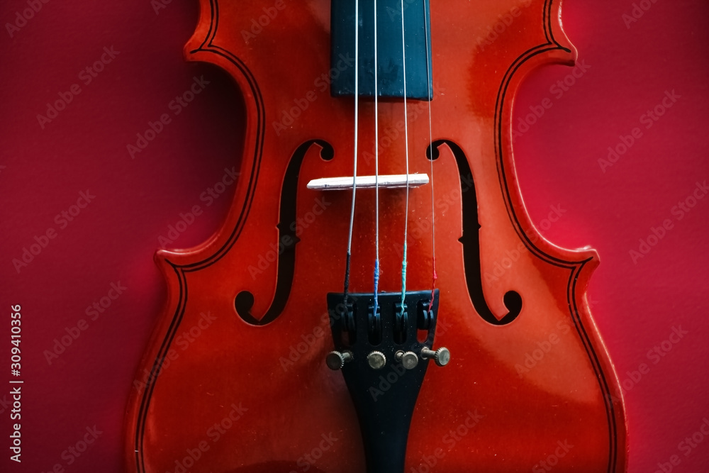 Fototapeta The abstract art design background of violin front side,show detail of string instrument,on red background,art style