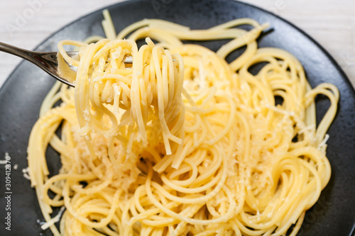 top view of fork with spaghetti over black plate