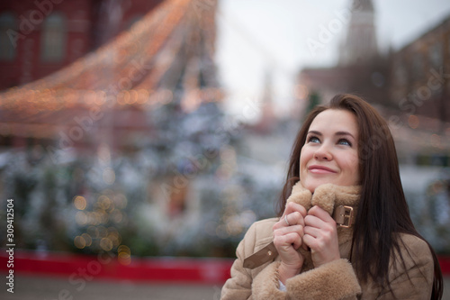 brown-haired girl on the background of Christmas lights