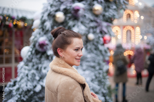 brown-haired girl on the background of Christmas lights